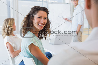 Casual businesswoman smiling at colleague during meeting