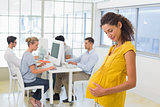 Pregnant casual businesswoman touching her belly