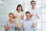 Casual business team showing thumbs up to camera