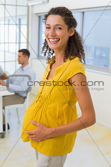 Casual pregnant businesswoman smiling at camera