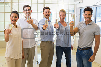 Casual business team toasting with champagne to camera