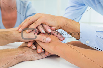 Casual business team putting hands together
