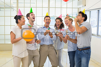 Casual business team celebrating with champagne and party poppers