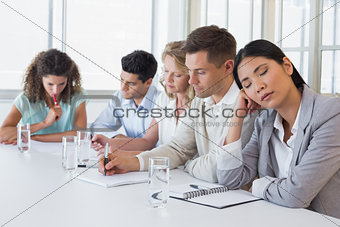 Casual businesswoman falling asleep during meeting