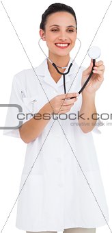 Pretty brown haired nurse listening with stethoscope