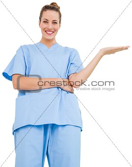 Pretty surgeon in blue scrubs presenting