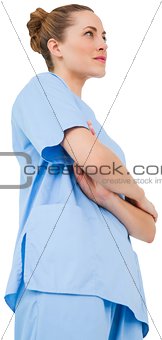 Pretty surgeon in blue scrubs with arms crossed