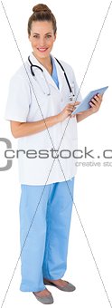 Pretty nurse in tunic using tablet pc