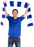 Football fan in blue holding scarf