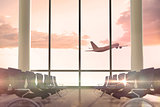 Airplane flying past departures lounge window
