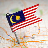 Malaysia Small Flag on a Map Background.