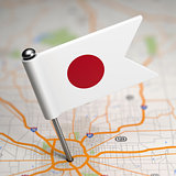Japan Small Flag on a Map Background.