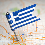 Greece Small Flag on a Map Background.