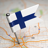 Finland Small Flag on a Map Background.