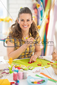 Smiling young woman making easter decoration