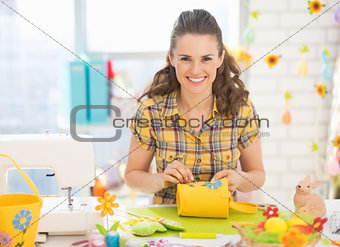 Happy young woman making easter decoration in studio