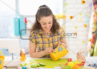 Happy young woman making easter basket in studio