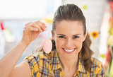 Portrait of smiling young woman showing easter decorative egg