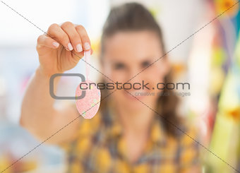 Closeup on young woman showing easter decorative egg
