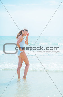 Young woman in swimsuit standing in sea