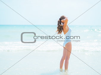 Relaxed young woman in swimsuit standing in sea