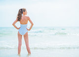 Full length portrait of young woman in swimsuit standing in sea