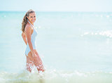 Happy young woman in swimsuit standing in sea