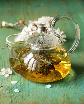 glass teapot with exotic green tea on a wooden table
