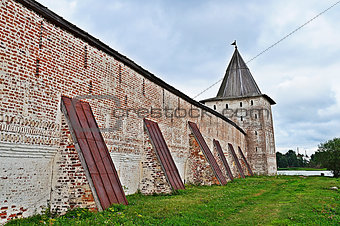 Wall with buttresses and tower of ancient monastery