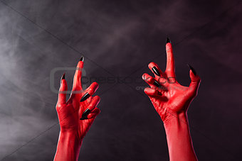 Creepy red devil hands with black sharp nails  