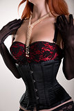 Busty redhead woman wearing corset, vintage red bra and sheer gl