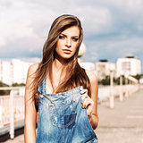 beautiful girl with long silky hair in denim short overalls