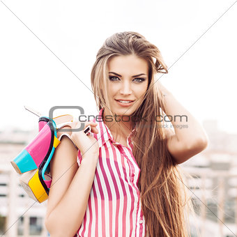beautiful woman in sleeveless striped top holding bright high he