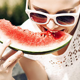girl in white summer dress eat watermelon