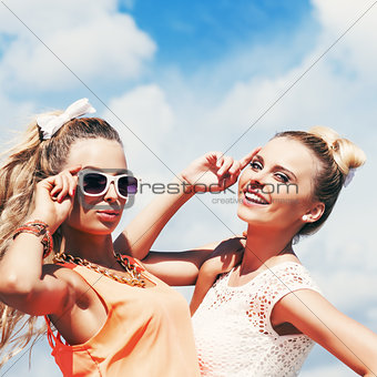 two young lady in summer apparel pose for the camera
