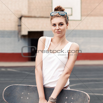 beautiful sexy lady in jeans shorts with skateboard at sport cou