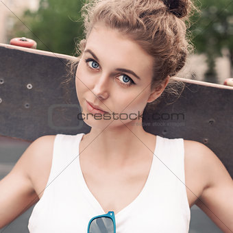 beautiful sexy lady in white t-shirt with skateboard at sport co