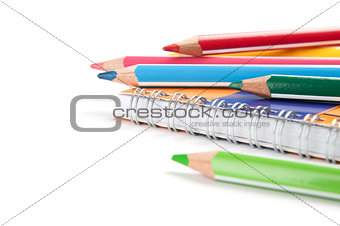 pencils and notebook on white background