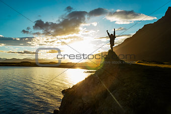 Silhouette boy staying on hill over the sun, Iceland