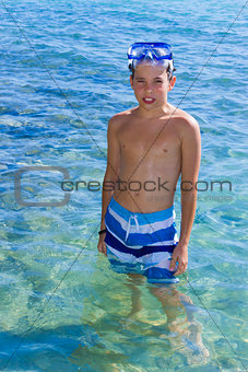 Cute eleven years old boy staying in the sea