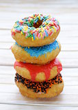 donuts with colorful glaze on the wooden background
