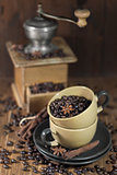 Coffee beans in the cups and old coffee mill