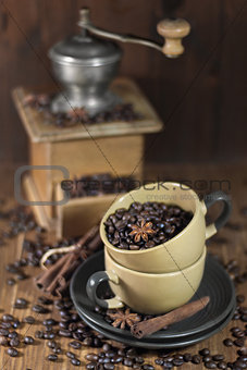 Coffee beans in the cups and old coffee mill