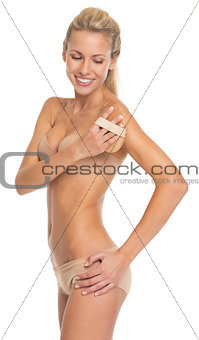 Happy young woman in lingerie using massager