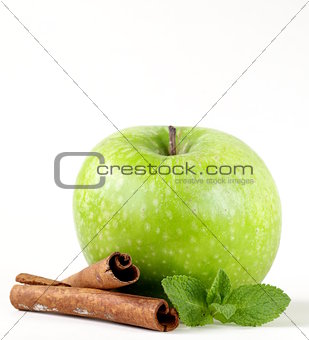 Granny Smith green apple with cinnamon and mint on a white background