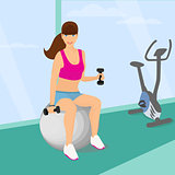 woman exercising with two dumbbell weights sitting on the fitness ball in the gym
