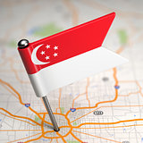 Singapore Small Flag on a Map Background.