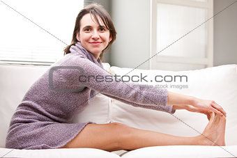 girl doing stretching exercises on her sofa