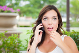 Stunned Young Adult Female Talking on Cell Phone Outdoors