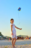 young girl flying a kite on the beach